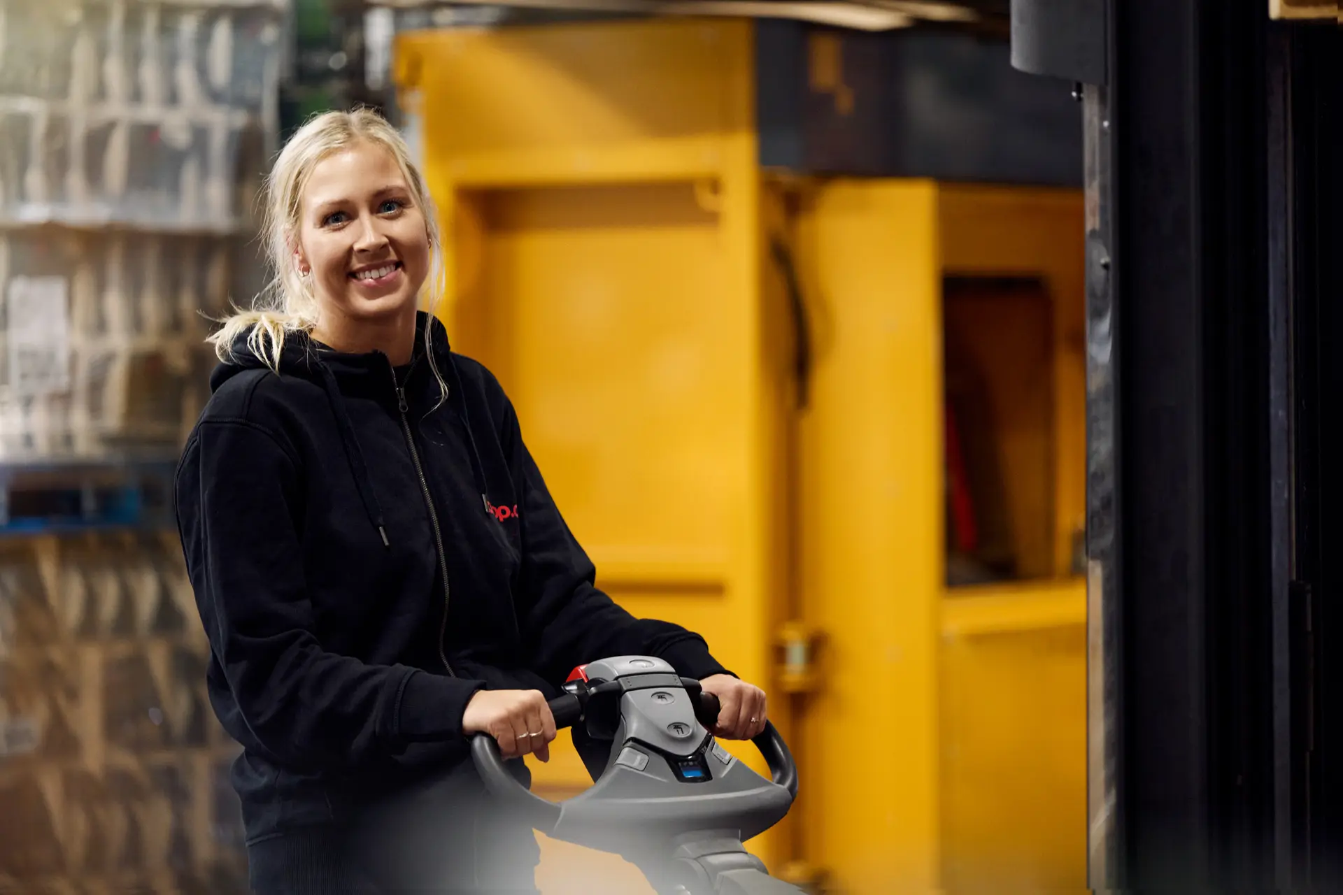 Lagermedarbejder på en palleløfter i et lager